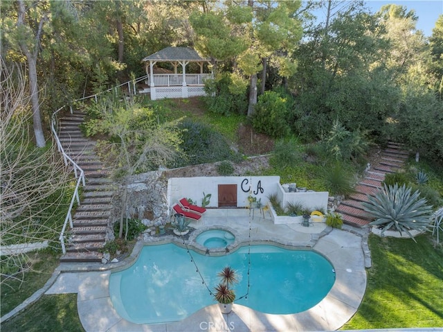 view of swimming pool with a gazebo, stairway, and a pool with connected hot tub