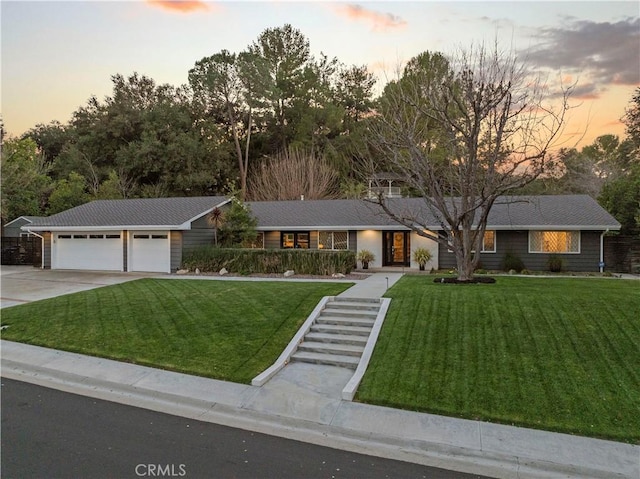 ranch-style house featuring a garage, driveway, and a front yard