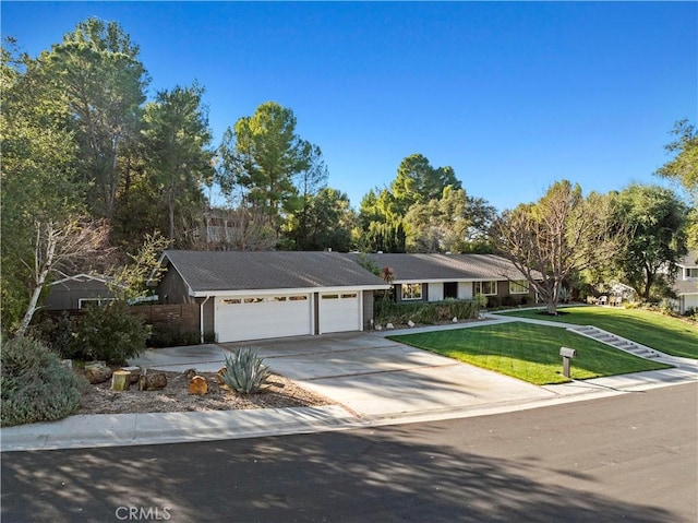 single story home featuring a garage, driveway, and a front lawn