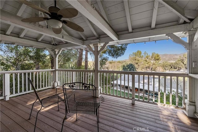 wooden terrace featuring a ceiling fan