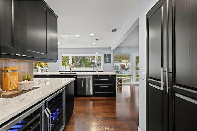 kitchen featuring a sink, beverage cooler, dishwasher, and dark cabinetry