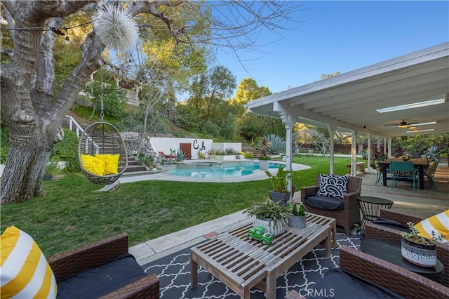 view of yard featuring an outdoor living space, a fenced in pool, ceiling fan, a fenced backyard, and a patio