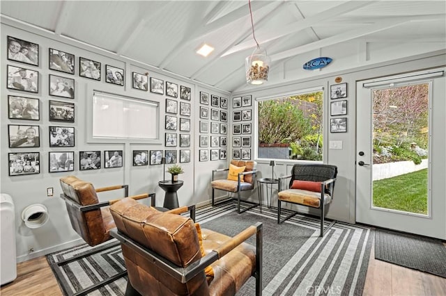 sunroom featuring vaulted ceiling with beams and a healthy amount of sunlight