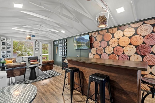 bar featuring a dry bar, lofted ceiling with beams, and wood finished floors