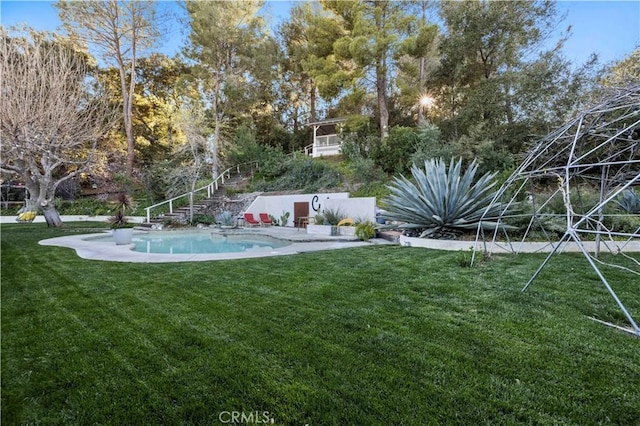 view of yard featuring an outdoor pool and stairway