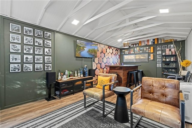 living area with a dry bar, lofted ceiling, and wood finished floors