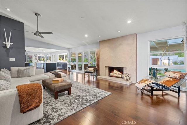 living area with a premium fireplace, lofted ceiling, recessed lighting, dark wood-style flooring, and ceiling fan