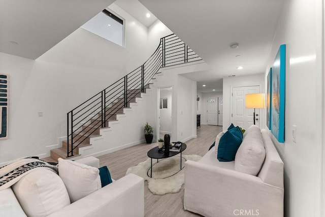 living room with stairway, recessed lighting, baseboards, and light wood-style floors