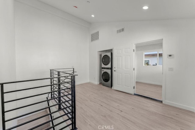 interior space with visible vents, stacked washer and clothes dryer, laundry area, and light wood-type flooring