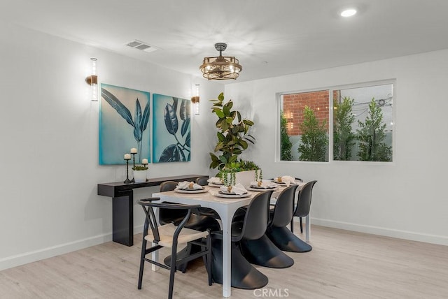 dining area with visible vents, baseboards, and wood finished floors