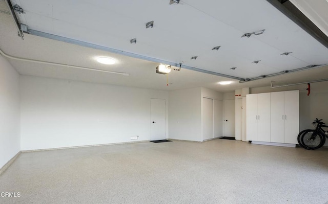 garage featuring a garage door opener and baseboards