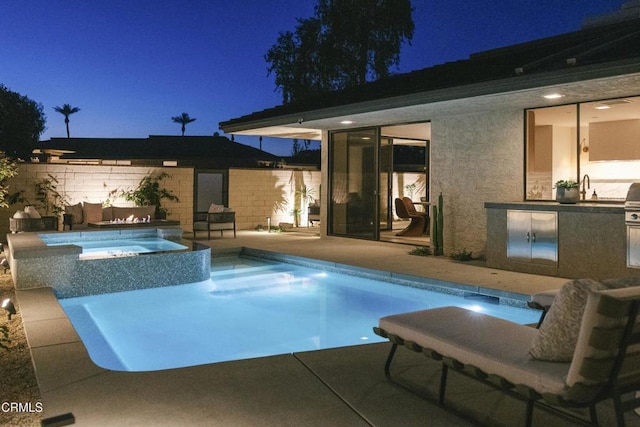 pool at twilight featuring area for grilling, a patio area, fence, and a pool with connected hot tub