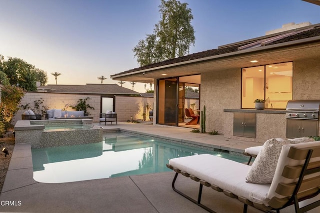 pool at dusk featuring a patio, fence, a pool with connected hot tub, and grilling area