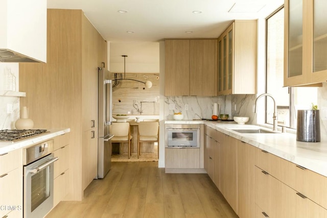 kitchen featuring decorative backsplash, stainless steel appliances, light countertops, and a sink