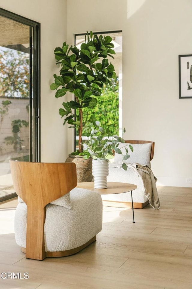 living area with baseboards and wood finished floors