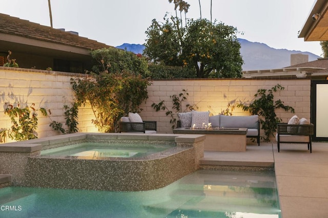 view of swimming pool with an in ground hot tub, a patio area, a mountain view, and an outdoor living space