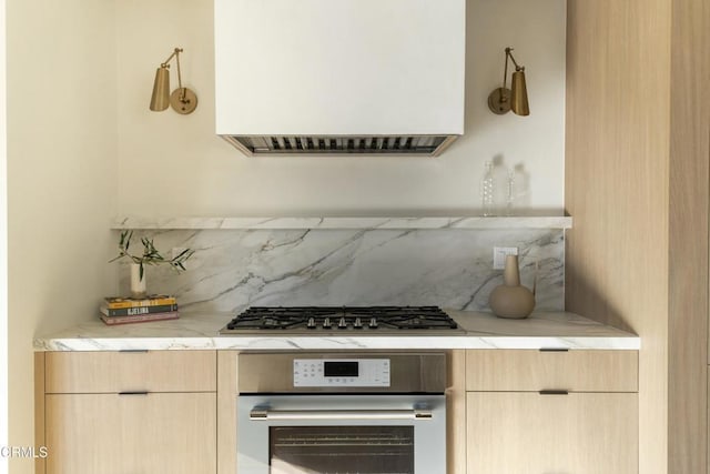 kitchen with stainless steel appliances, tasteful backsplash, and light brown cabinetry