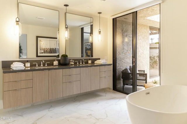 bathroom with double vanity, a freestanding bath, a sink, floor to ceiling windows, and marble finish floor