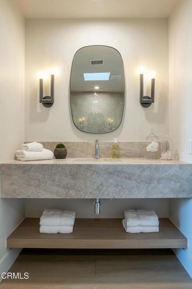35 Lafayette Dr, Rancho Mirage, CA 92270 - bathroom featuring a sink, wood finished floors, and baseboards