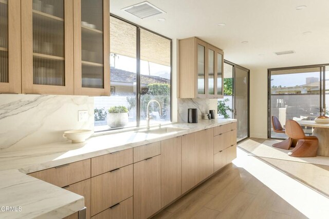 35 Lafayette Dr, Rancho Mirage, CA 92270 - kitchen featuring a sink, light brown cabinets, light stone counters, light wood-style floors, and decorative backsplash