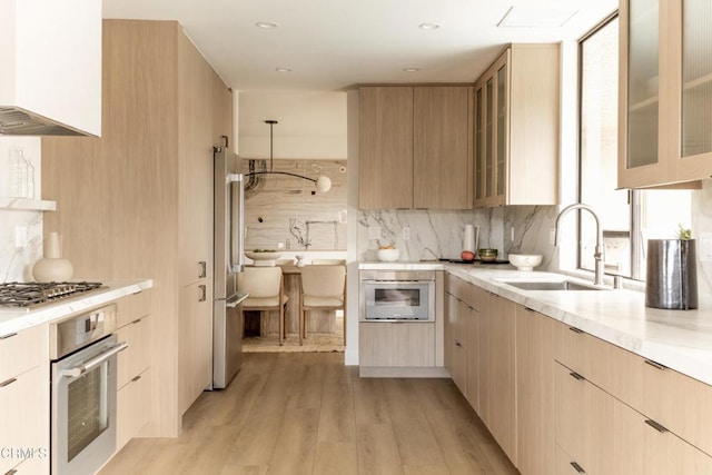 35 Lafayette Dr, Rancho Mirage, CA 92270 - kitchen with stainless steel appliances, a sink, modern cabinets, light brown cabinets, and decorative backsplash
