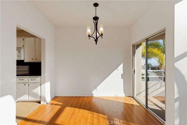 16061 Surprise Ln, Huntington Beach, CA 92649 - dining area with a notable chandelier, baseboards, and light wood finished floors