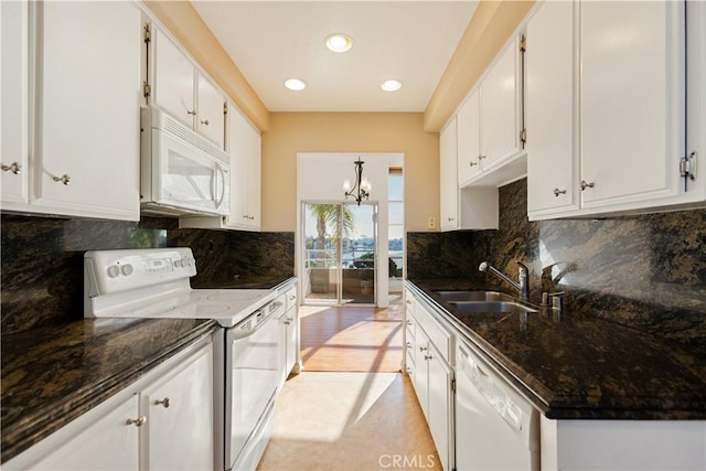 16061 Surprise Ln, Huntington Beach, CA 92649 - kitchen featuring dark stone counters, an inviting chandelier, white appliances, white cabinetry, and a sink