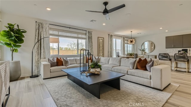 living room featuring a wealth of natural light, visible vents, recessed lighting, and light wood finished floors