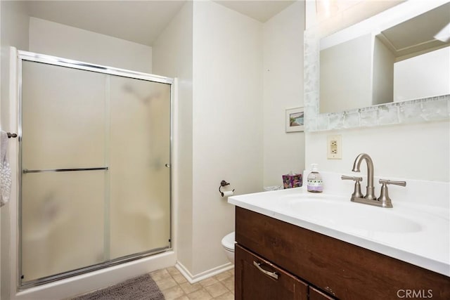 full bathroom with a shower stall, toilet, vanity, and baseboards