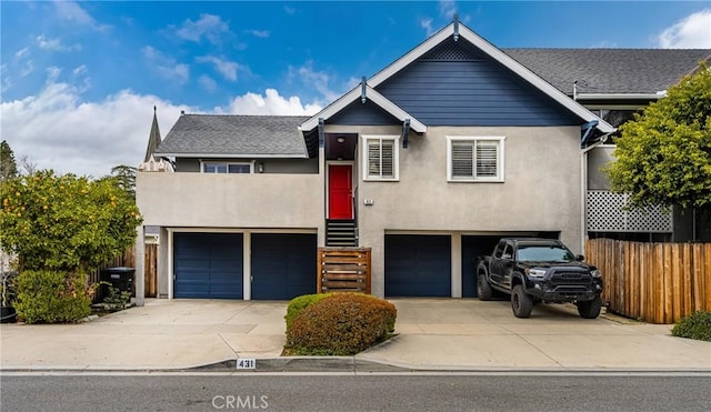 view of front facade featuring stucco siding, entry steps, fence, concrete driveway, and an attached garage