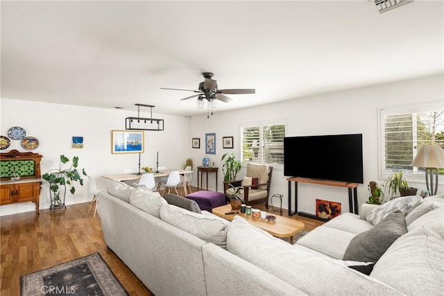 living area featuring visible vents, a ceiling fan, and wood finished floors