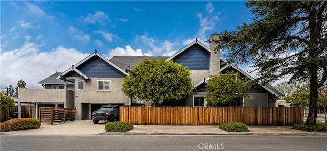 view of front of house with a fenced front yard, a carport, concrete driveway, and stucco siding