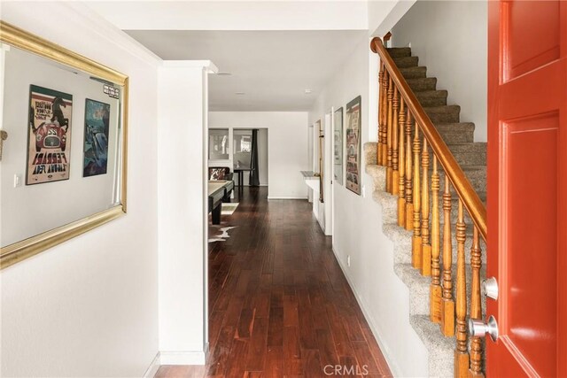 hall featuring stairs, baseboards, and wood finished floors