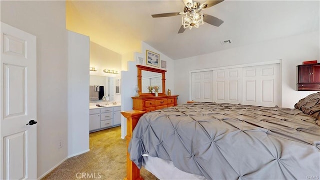 bedroom with visible vents, ensuite bath, vaulted ceiling, a closet, and light carpet