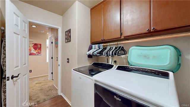 washroom with carpet, cabinet space, baseboards, and washer and clothes dryer