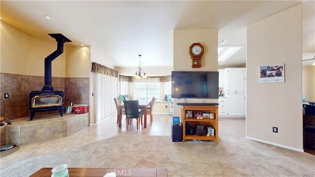 living area with carpet flooring, lofted ceiling, a wood stove, and baseboards