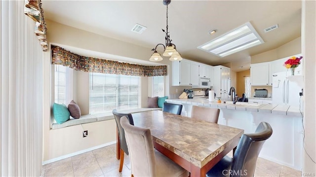 dining room featuring light tile patterned flooring, visible vents, and baseboards