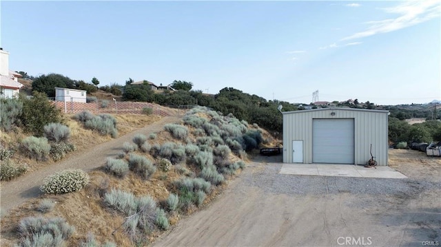 view of yard featuring a detached garage and an outbuilding