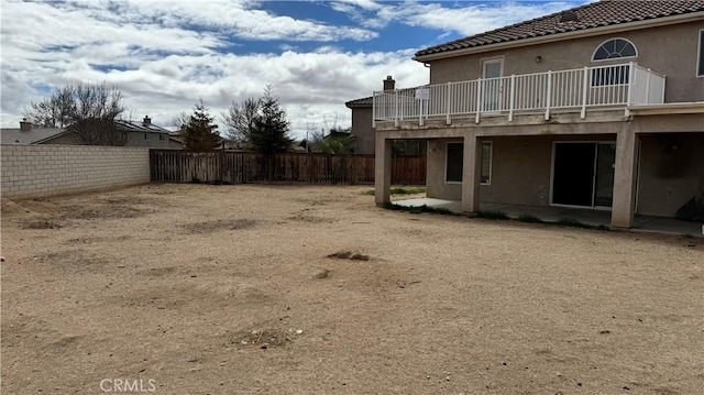 view of yard with a patio, a balcony, and a fenced backyard