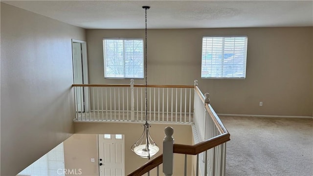 staircase featuring carpet flooring and baseboards