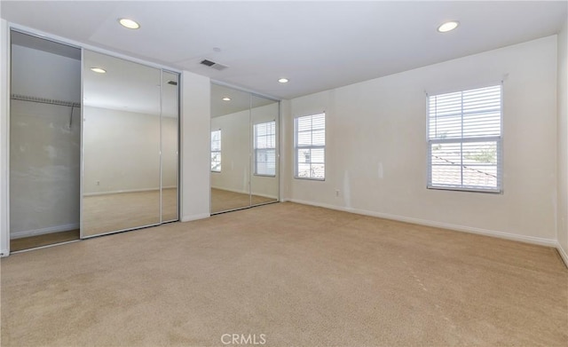 unfurnished bedroom with visible vents, baseboards, multiple closets, carpet floors, and recessed lighting