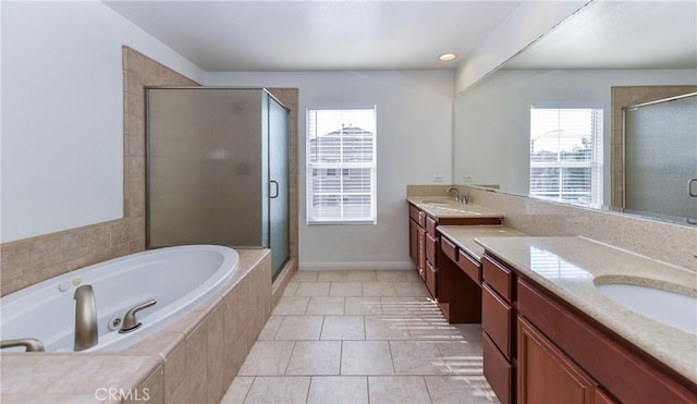 bathroom with a shower stall, two vanities, a garden tub, and a sink