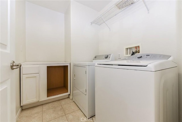 clothes washing area with light tile patterned floors and separate washer and dryer