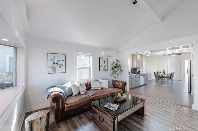 living room with a wall unit AC, wood finished floors, baseboards, and beam ceiling