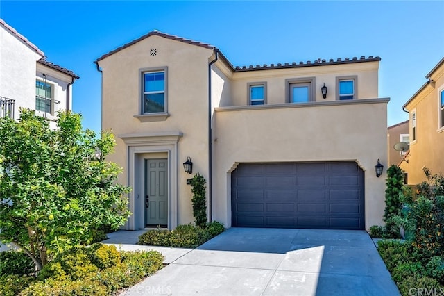 mediterranean / spanish home featuring stucco siding, a garage, concrete driveway, and a tile roof