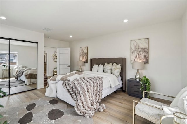 bedroom featuring visible vents, recessed lighting, wood finished floors, and a closet