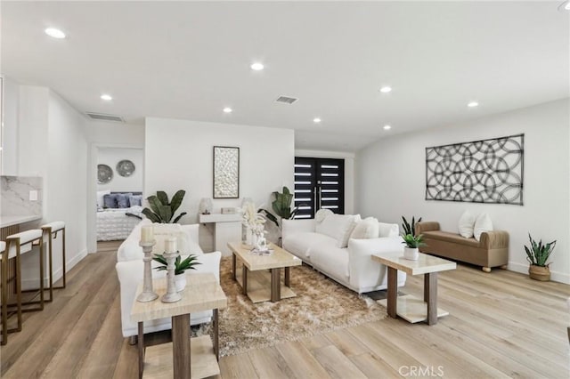 living room with visible vents, recessed lighting, baseboards, and light wood finished floors