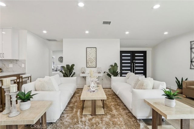 living room with recessed lighting, visible vents, and baseboards