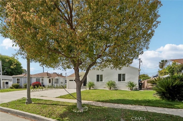 ranch-style home featuring fence, driveway, an attached garage, stucco siding, and a front lawn