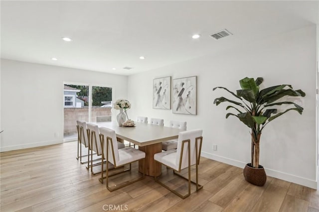 dining room with visible vents, light wood-type flooring, and baseboards